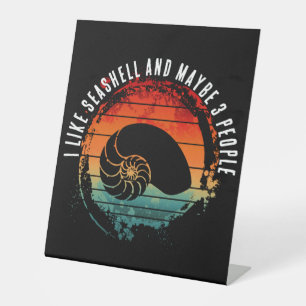 I LIKE SEASHELL AND MAYBE 3 PEOPLE PEDESTAL SIGN