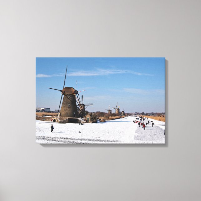 Ice skating along the windmills in winter canvas print (Front)