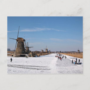 Ice skating along the windmills in winter postcard