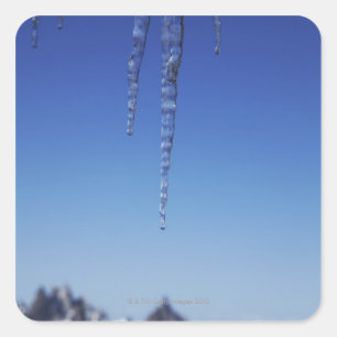 Icicles and snow-covered mountains square sticker
