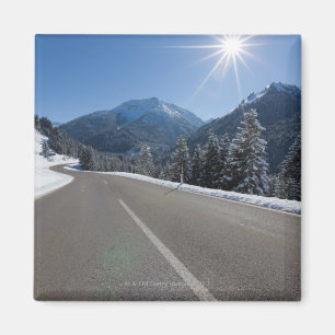 Idyllic empty road thrugh a winter landscape, magnet
