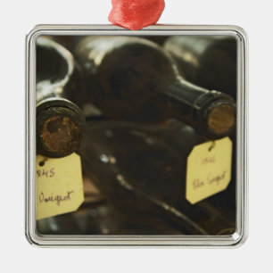 In the underground wine cellar: lying bottles in metal tree decoration