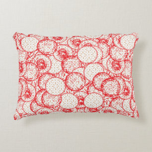 Intricate textile design featuring red, gold, and  decorative cushion