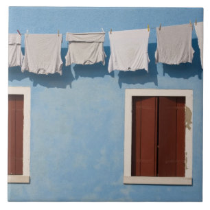 Italy, Burano. Hanging laundry and windows along Tile