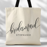 Ivory Cream Bridesmaid Modern Script Tote Bag<br><div class="desc">Show your appreciation to your bridal party with this stylish ivory cream bridesmaid tote bag. Featuring modern script and customisable with your bridesmaid's name, this tote bag is both practical and elegant. The soft colour and chic design make it perfect for carrying wedding day essentials or everyday items. This personalised...</div>