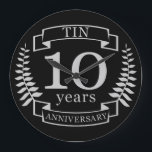 Ivory Traditional wedding anniversary 10 years Large Clock<br><div class="desc">A design to celebrate 10 years of marriage. This design has a Grey / silver (the traditional colour for this anniversary) coloured laurel design on a black background. Tin is the traditional gift for this occasion. The text reads Tin 10 years anniversary. A romantic design to celebrate your 10th year...</div>