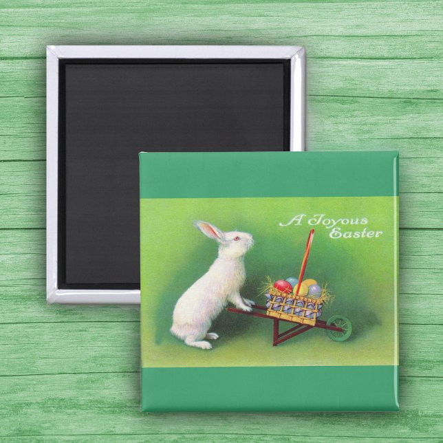 Joyous Easter Bunny and Wheelbarrow  Magnet (White Easter Rabbit pushing wheelbarrow with coloured Easter Eggs on green Magnet.)