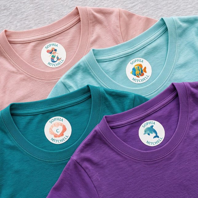 Kids Name Personalised Mermaid School Iron On  (Create a realistic product mockup showing four children's t-shirts overlapping in a layered arrangem)