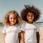 Kids Personalised Name Tee | Gold<br><div class="desc">These personalised children's t-shirts feature your child's name or other custom text in a stylish, modern arched font, adding a playful and unique touch to their wardrobe. Made from soft, high-quality fabric, these custom tees are perfect for everyday wear, special occasions, or as a thoughtful gift. Let your little one...</div>