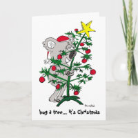 Koala bear hugging a Christmas tree