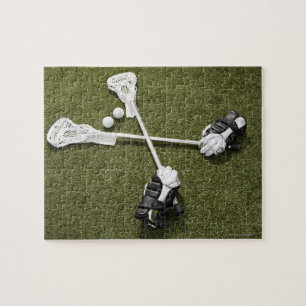 Lacrosse sticks, gloves and balls on artificial jigsaw puzzle