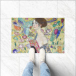 Lady with A Fan, Gustav Klimt Doormat<br><div class="desc">Gustav Klimt (July 14, 1862 – February 6, 1918) was an Austrian symbolist painter and one of the most prominent members of the Vienna Secession movement. Klimt is noted for his paintings, murals, sketches, and other objets d'art. In addition to his figurative works, which include allegories and portraits, he painted...</div>