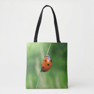Ladybug on a blade of grass tote bag