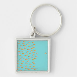 Large group of goldfish facing one lone goldfish key ring