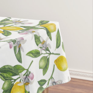 Lemon branches with blossoms and fruit on white tablecloth
