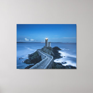 light house and rocks at dusk canvas print