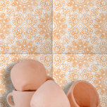 Light Orange White Ornate Symmetrical Geometric Tile<br><div class="desc">This ceramic tile features an intricate design that is both symmetrical and sophisticated. The design is chraacterised by ornate, white floral and geometric shapes that contrast beautifully against a warm, peach-coloured background. The tile's design is centred around a diamond-shaped element, surrounded by elegant swirls and curves. This central motif is...</div>