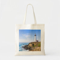 Lighthouse on hill blue sky white house ocean