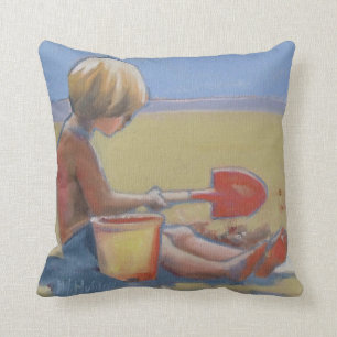 Little boy playing in the sand with a shovel cushion