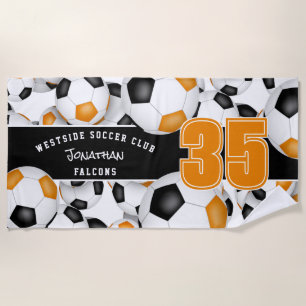 Lots of soccer balls orange black team colours beach towel
