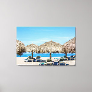 Lounge Chairs And Thatch Umbrellas On Beach Canvas Print