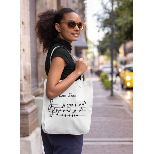 Love song, birds sitting in between musical notes  tote bag