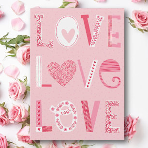 Love text in pink shades with hearts and flowers holiday card