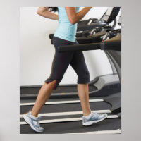 Low section of woman walking on treadmill