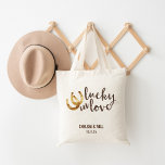 Lucky in Love Horseshoe Wedding Favor Tote Bag<br><div class="desc">Design features two golden horseshoes and “Lucky in Love" in warm autumn brown watercolor. Great wedding favor or welcome bag for out of town guests. Coordinating accessories available in our shop!</div>