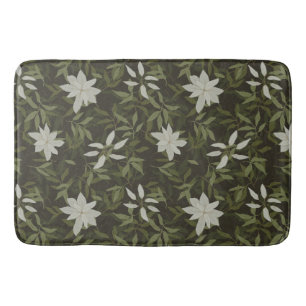 Magnolia and green leaves on black bath mat