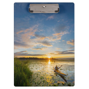Male kayaker paddling sea kayak on still water clipboard