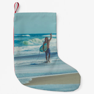 Man carrying surfboard at beach small christmas stocking