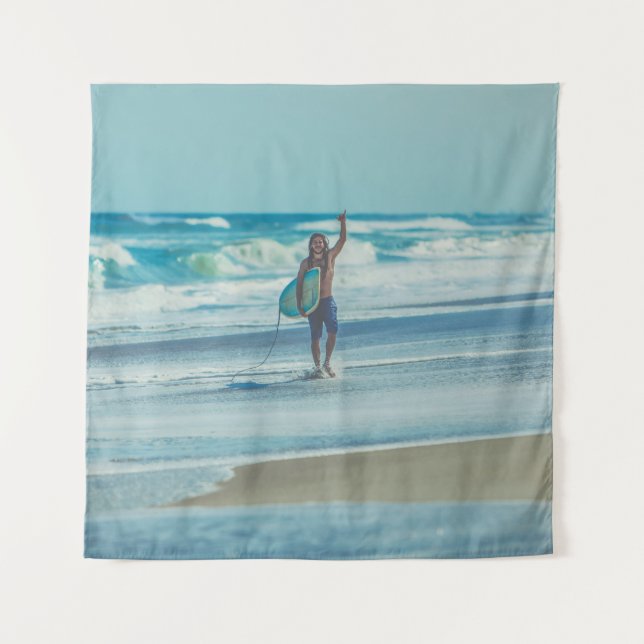 Man carrying surfboard at beach tapestry (Front)
