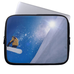 Man flying through the air on a snowboard with laptop sleeve