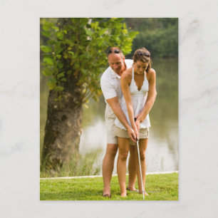 Man helping woman golf postcard