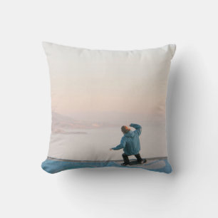 Man in blue skateboarding on wall in beach cushion