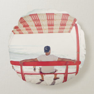 Man sitting on bench near beach round cushion