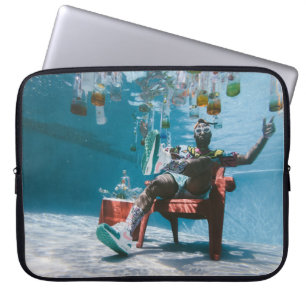 Man sitting on chair underwater with floating bott laptop sleeve