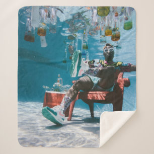 Man sitting on chair underwater with floating bott sherpa blanket