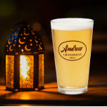 Maroon Stylised Wedding Groomsman Name Glass<br><div class="desc">Beer glass for the wedding groomsman that features his name printed in dark maroon, stylised script inside a maroon colour oval border along with wedding date. A great party supply idea for a bachelor party! Personalise your beer glass by editing and replacing name and date with your own. Available in...</div>