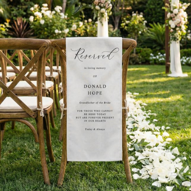 Memorial Wedding Chair Sign Reserved Cloth (White memorial chair fabric sign with elegant script on wooden ceremony chair outdoors)