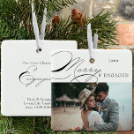 Merry and Engaged Photo and Elegant Calligraphy Ceramic Ornament<br><div class="desc">Merry & Engaged Christmas photo ornament which you can personalise with your favourite photo and persoanlized wording. Elegant typographic design with swirly calligraphy and easy to edit for an engaged couple. This holiday ornament is lettered with Merry & Engaged on one side and editable text on the other. The sample...</div>