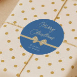 Merry Christmas Blue & Cream Ribbon Handwritten Classic Round Sticker<br><div class="desc">Add the finishing touch to your gift packaging this holiday season with these elegant dusty blue and cream beige Christmas round stickers. Featuring handwritten style font that reads 'Merry Christmas',  a hand drawn whimsical bow in white with your custom name underneath.</div>