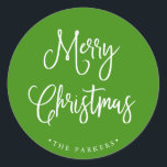 Merry Christmas | Handwritten Script on Green Classic Round Sticker<br><div class="desc">This simple and trendy holiday sticker says "Merry Christmas" in rustic,  white handwritten script on a bright,  holiday green background.</div>