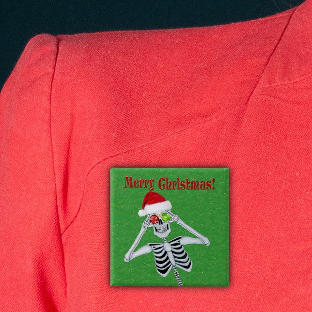 Merry Christmas Happy Skeleton Santa Hat Green 15 Cm Square Badge (Happy Christmas skeleton holding ornaments in Santa Hat on green with gold flecks pin back button.)