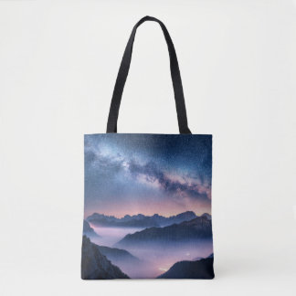 Milky Way over mountains in fog at night in summer Tote Bag