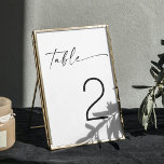 Minimalist Black & White Modern Script Wedding Table Number<br><div class="desc">Elevate your wedding decor with this minimalist black and white table number, featuring elegant script typography. The design offers a clean and modern aesthetic, making it a versatile choice for various wedding themes, including contemporary, rustic, or classic styles. Ideal for couples seeking a sophisticated and timeless look, this table number...</div>