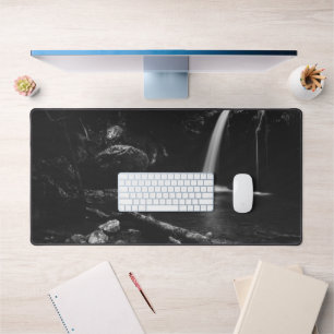 Minimalistic waterfall behind broken tree in black desk mat