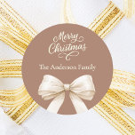 Mocha coffee cream bow Christmas Classic Round Sticker<br><div class="desc">A muted mocha coffee background,  cream coloured text and bow.  Merry Christmas is written with an elegant hand-lettered style script.  Personalise and add your family name.</div>