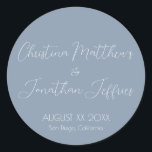 Modern and Elegant Dusty Blue Wedding Classic Round Sticker<br><div class="desc">This modern and elegant event or wedding sticker features a simple dusty blue background with white text. The names of the couple are printed in a script font. The wedding date and location are printed below.</div>